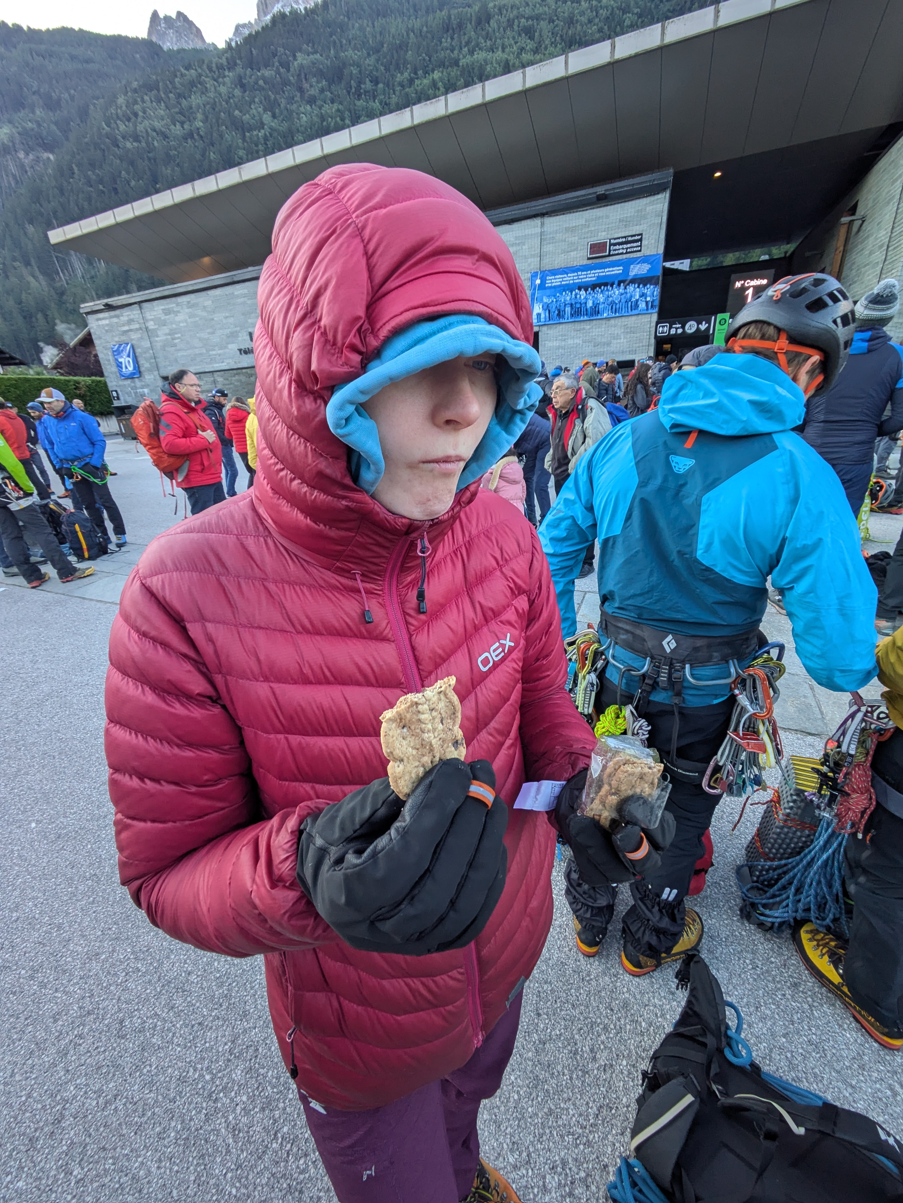 Tilly eating a biscuit, backed by a crowd of climbers